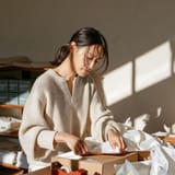 Woman folding a kraft box at a packing table