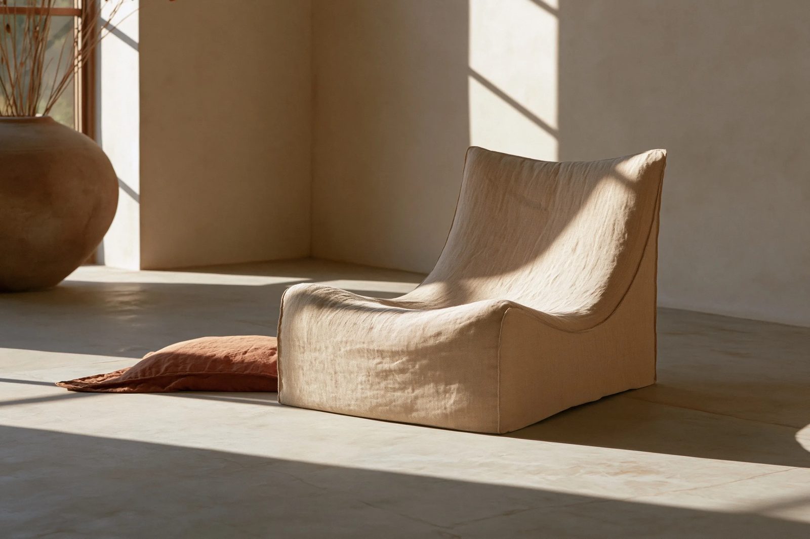 quiet luxury aesthetic, a linen lounge chair in a curated minimal concrete room, soft directional window light, warm sand and terracotta tones, low-contrast film-like grade, faint warm cast, shallow depth of field, natural linen texture, editorial commercial photography --ar 3:2 --style raw --preview