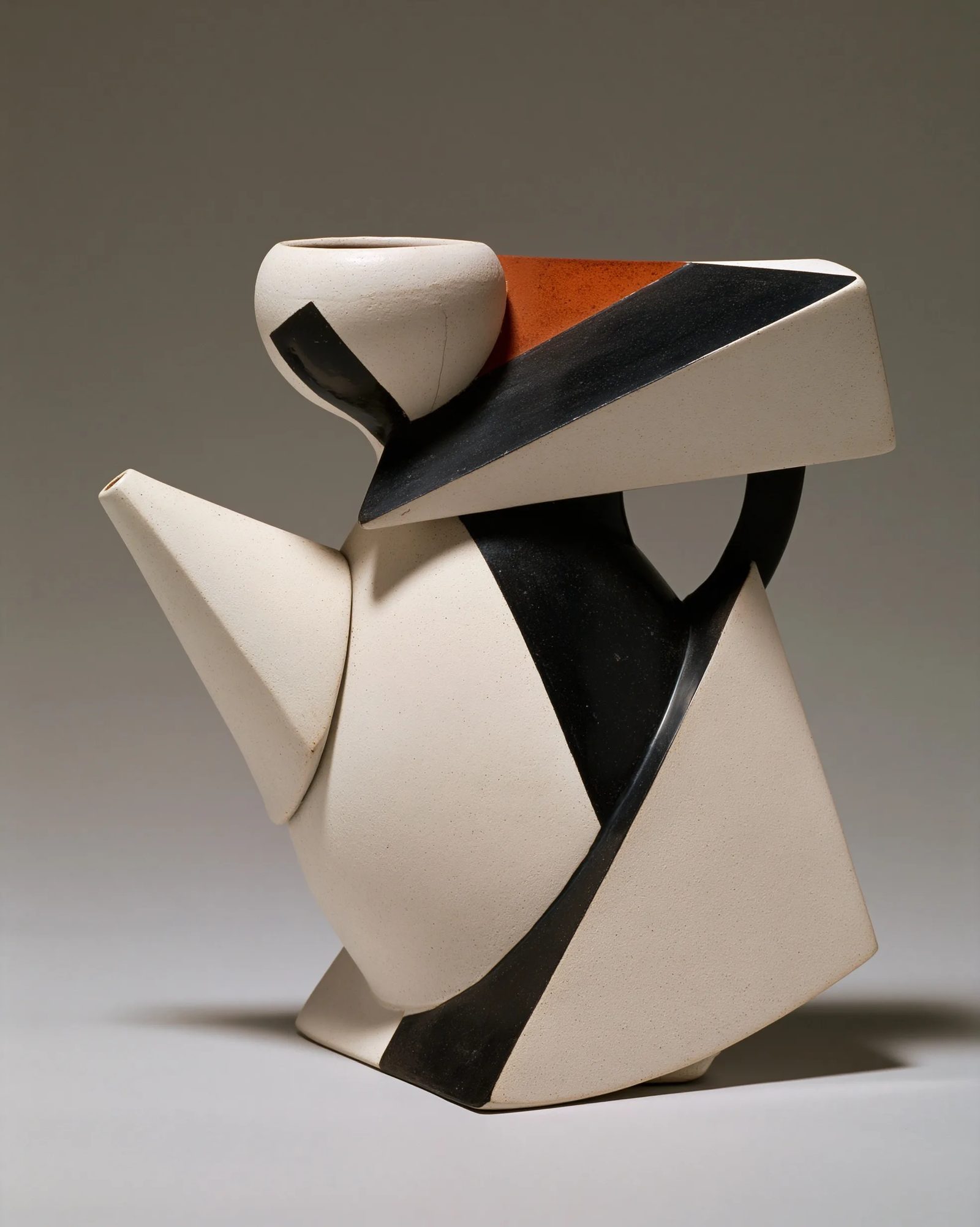 a white ceramic teapot in vorticism, hard diagonal facets slicing the ceramic body, converging sharp planes, stark black and white with rust accent, machine-age geometric abstraction, graphic flat light --ar 4:5 --style raw --s 50 --preview