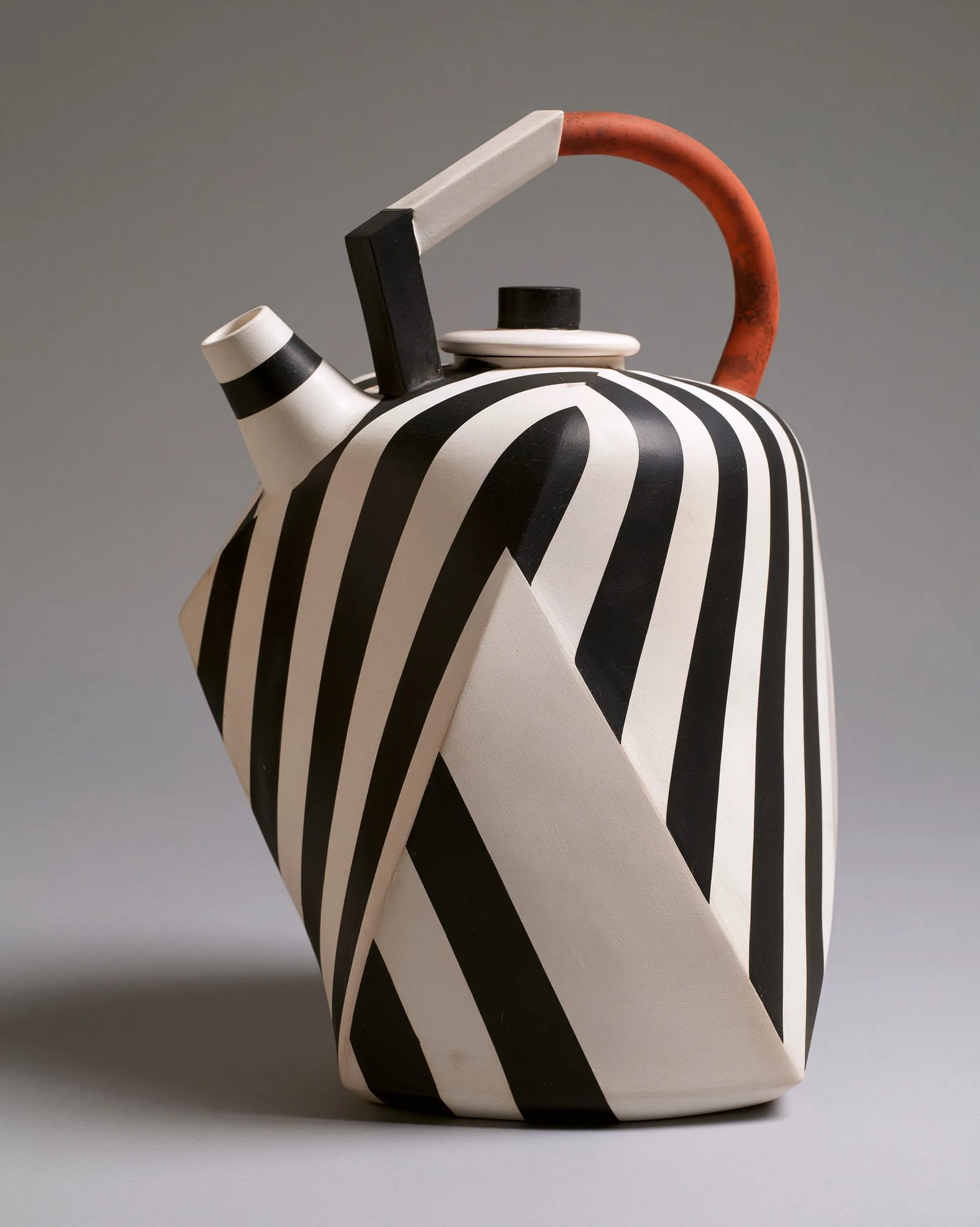 a white ceramic teapot in vorticism, hard diagonal facets slicing the ceramic body, converging sharp planes, stark black and white with rust accent, machine-age geometric abstraction, graphic flat light --ar 4:5 --style raw --s 50 --preview