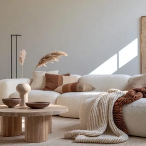 A cozy living room with a plush sofa and knitted throws bathed in an autumnal palette.