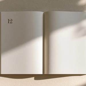A spread of two aged book pages with the folio number '12' set in a serif typeface in the top-left corner of the left page.