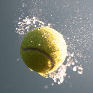 A wet yellow tennis ball spinning in mid-air, shot with a freeze-motion shutter at 1/8000s, water droplets radiating off its surface suspended in mid-flight with zero motion blur and razor-sharp detail, bright direct sunlight --ar 4:3 --raw --profile 9qzq3j7 --stylize 50 --preview