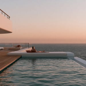 A quiet-luxury oceanview infinity pool on a modern cruise deck merges with the calm blue sea at sunset.