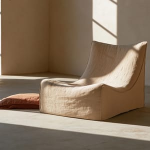 quiet luxury aesthetic, a linen lounge chair in a curated minimal concrete room, soft directional window light, warm sand and terracotta tones, low-contrast film-like grade, faint warm cast, shallow depth of field, natural linen texture, editorial commercial photography --ar 3:2 --style raw --preview