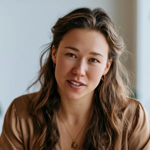 Gentle soft directional lighting sculpts the features of a candidate during an HR interview, creating soft shadows across a warm, woman, minimal corporate office.
