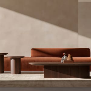 A wide architectural photograph of a modern office lounge styled with subdued earth tones, showcasing warm terracotta, sand, and deep brown accents.