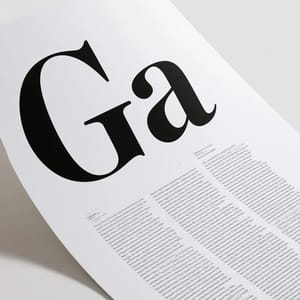 A typographic type specimen sheet displaying bold black serif letterforms printed on heavy cream cotton paper.