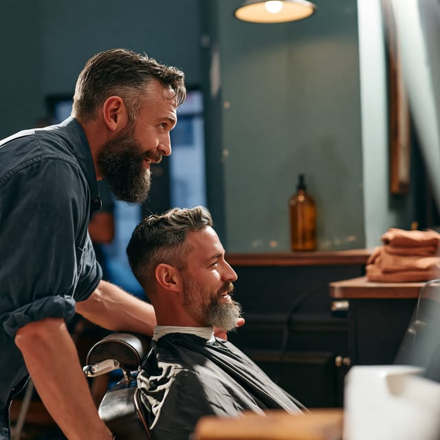 Barber discussing a cut with a seated client in profile