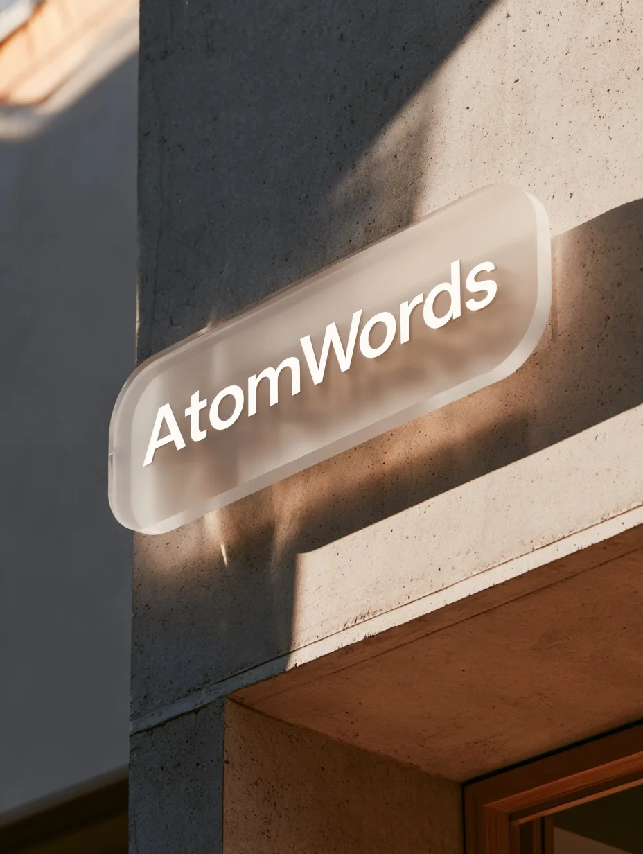 A minimalist AtomWords storefront sign made from a translucent blur PMMA material is mounted on a concrete wall under bright sunlight.