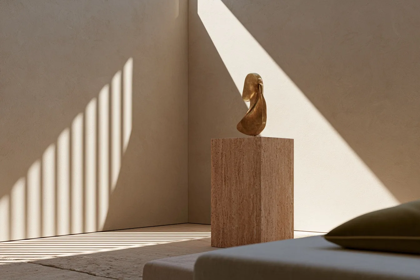 A luxury boutique interior featuring minimal plaster walls, a single travertine display plinth, and warm ambient light.