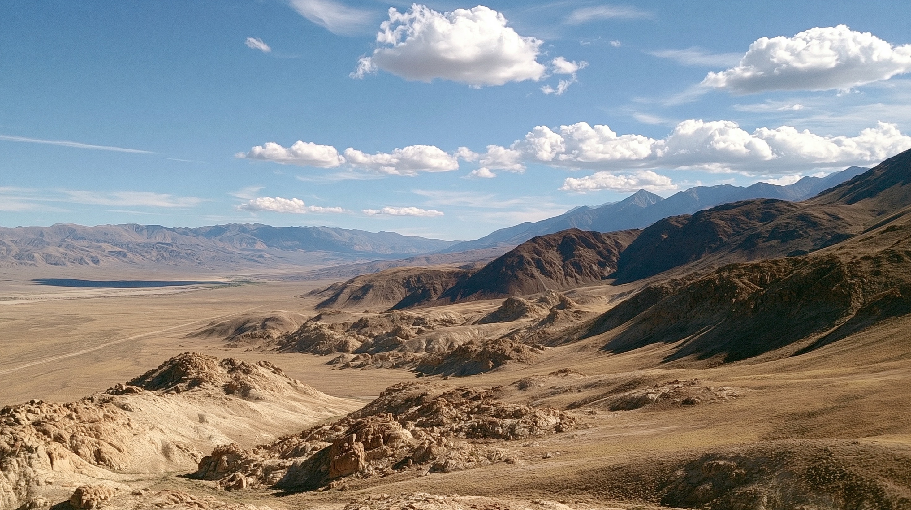 A wide shot of a valley, the surrounding hills and open sky filling the frame around it.