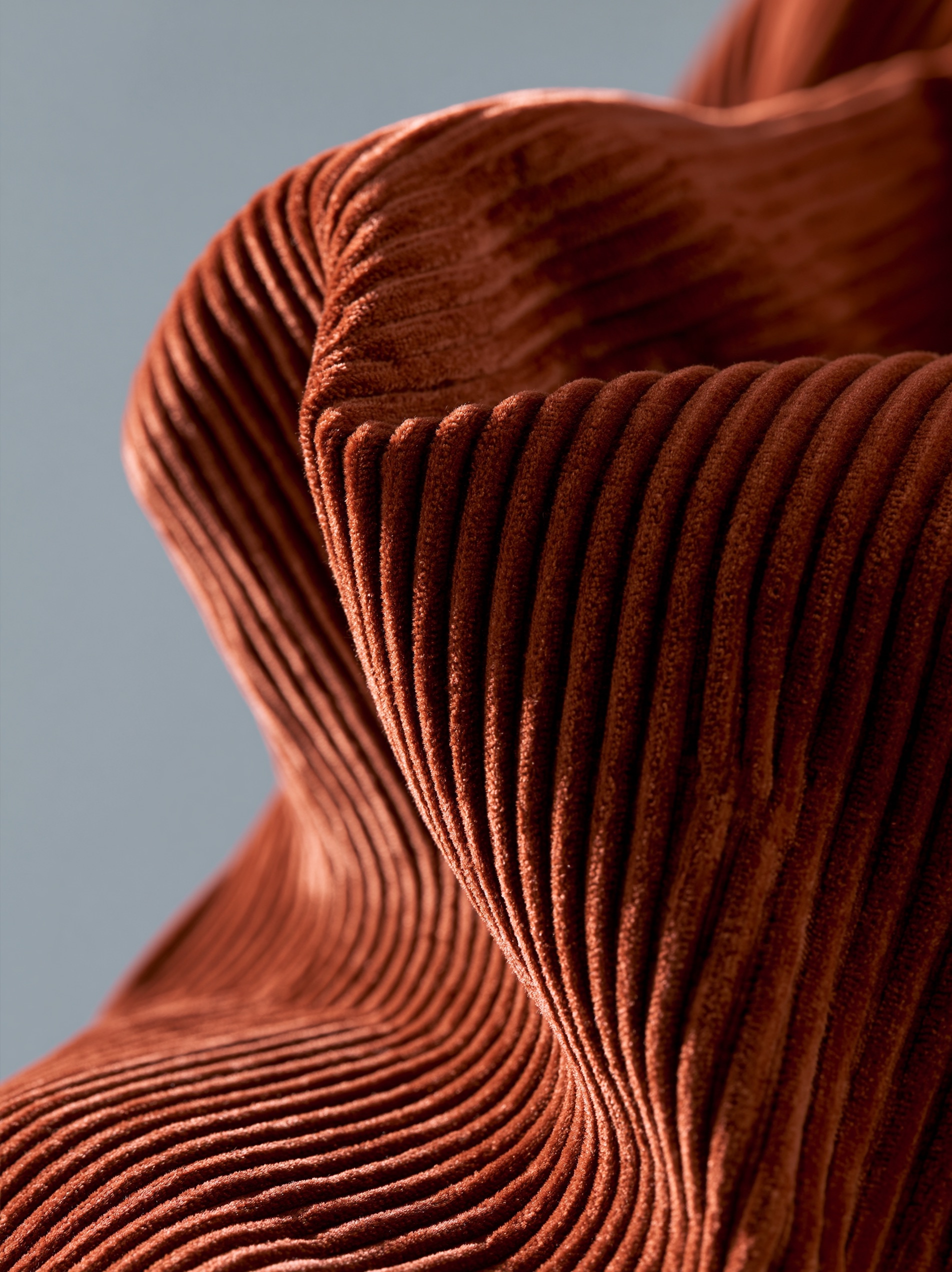 A macro close-up of a structured jacket crafted from wide-wale corduroy under soft side lighting.